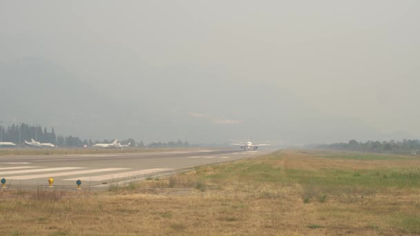 Vliegtuig landt op de landingsbaan in de rook van de branden. — Stockvideo