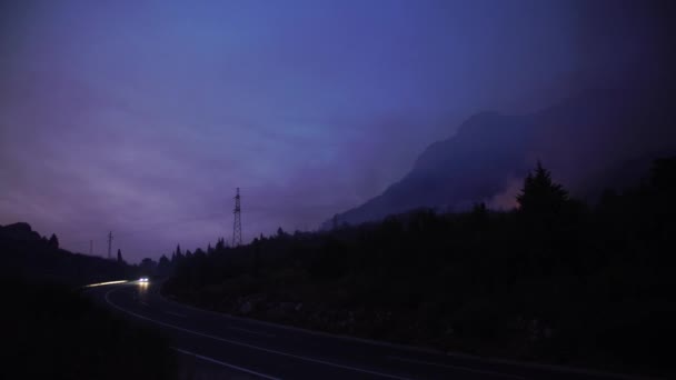 Heldere blauwe zonsondergang over een bergweg tegen een achtergrond van bosbranden — Stockvideo