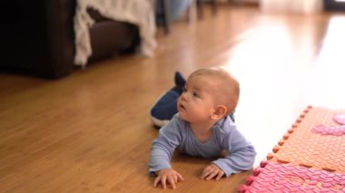 Gülümseyen bebek mutfaktaki karnında emekliyor.