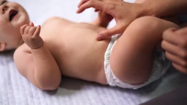 Las manos femeninas masajean la barriga de un bebé riendo — Vídeos de Stock