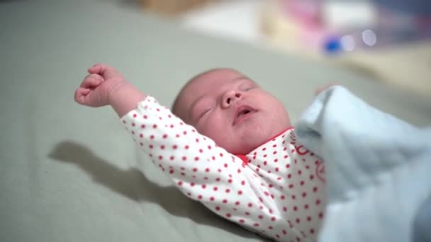 Bebé soñoliento bosteza y se estira en la cama — Vídeo de stock