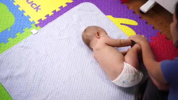 Anne yan ve arka tarafta bebeği çeviriyor. — Stok video