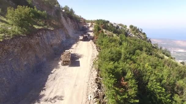 Camiones con tierra están conduciendo en la carretera en las montañas — Vídeo de stock