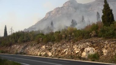 Otoyolun üstündeki dağ çalılıklarında bir yangından çıkan duman.