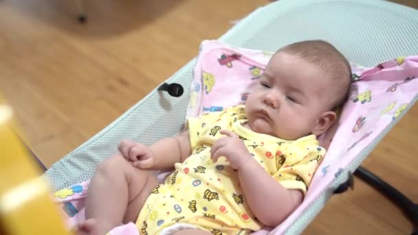 Yeni doğmuş bebek sallanan bebek sandalyesinde sallanıyor — Stok video