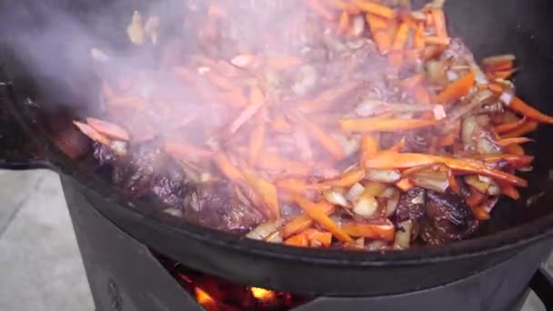 Cenouras com carne são cozidas em um caldeirão. Pilaf uzbeque — Vídeo de Stock