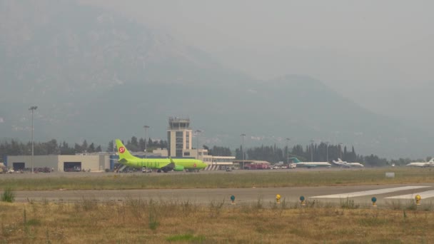 Gli aerei in piedi sulla pista nel fumo degli incendi in montagna — Video Stock