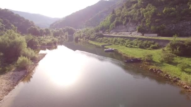 Crnojevica folyó parkoló csónakokkal a parton, és gyönyörű kilátás nyílik a zöld hegyek körül — Stock videók