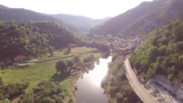 Drone view of the Crnojevica river, stone bridge and houses on the shore — Stock Video