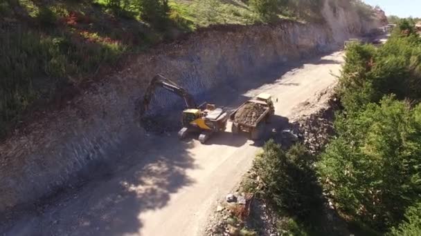 Mit Erde beladener Lastwagen fährt auf der Straße an einem Bagger vorbei — Stockvideo