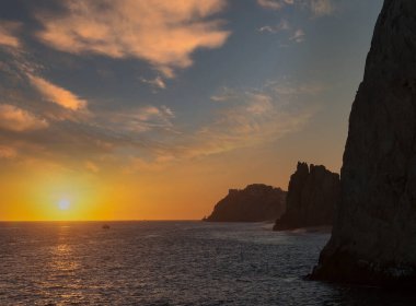 Güneş, Cortez Denizi üzerinden Cabo San Lucas, Meksika 'daki Lands End' de batıyor.