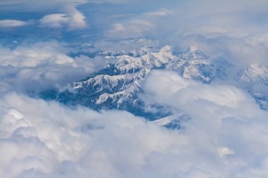 Beyaz bulut örtülü görkemli Denali dağ sırasının hava görüntüsü.