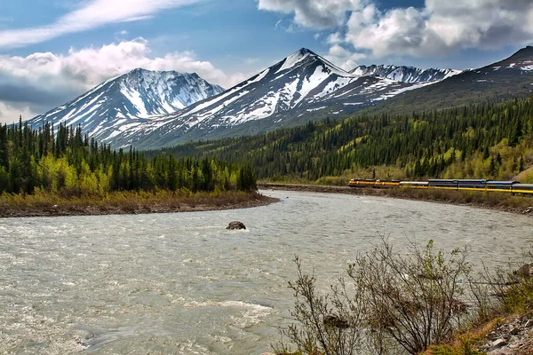 アラスカの国境を横断する列車 山の峰を通過し 川を流れる — ストック写真