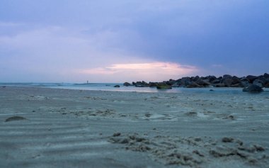 Gün batımında Hollanda kıyısı boyunca çamurlu