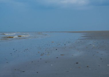 Gün batımında Hollanda kıyısı boyunca çamurlu