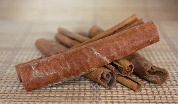 Dried cinnamon on straw mat — Stock Photo, Image