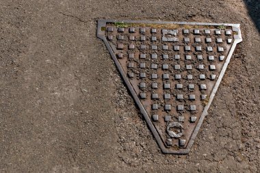Bristol-Kasım 2020, İngiltere kanalizasyon sistemine kolay erişim için katranlı yola yerleştirilen metal bir delik kapağının yakın görüntüsü 