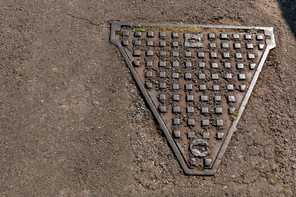 Bristol-Kasım 2020, İngiltere kanalizasyon sistemine kolay erişim için katranlı yola yerleştirilen metal bir delik kapağının yakın görüntüsü 