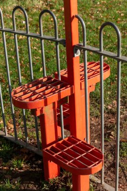 Halka açık bir çitte çitin üzerinden tırmanmanızı sağlayan metal basamakların yakın görüntüsü. 