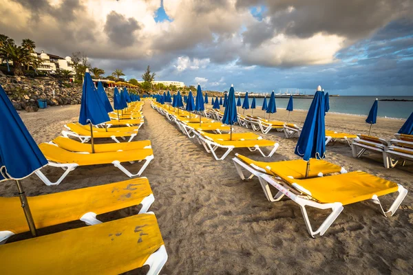 Красивые шезлонги с зонтиками на пляже — стоковое фото