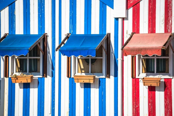 Bunt gestreifte Fischerhäuser in blau und rot, costa nova, — Stockfoto