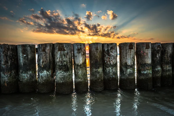 Puesta de sol en la playa con un rompeolas de madera en Leba, Mar Báltico, Po —  Fotos de Stock