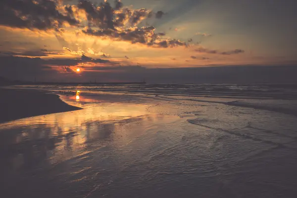 Sunset on beach with a wooden breakwater in Leba, Baltic Sea, Po — Stock Photo, Image