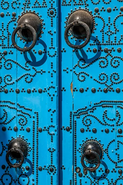 Modré dveře s černými knoflíky a kamenná ozdoba na dveře v Tu — Stock fotografie