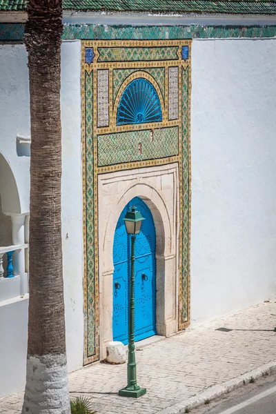 Uma porta azul com pregos pretos e ornamento de pedra na porta em Tu — Fotografia de Stock