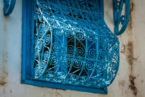 Hermosas ventanas azules ornamentales en una pared blanca tan típica para — Foto de Stock