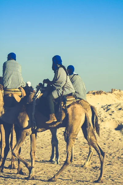 Beduins vede turisty na velbloudy na krátké turistické turné po — Stock fotografie