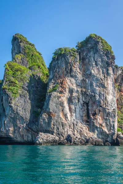 Cliff e o mar claro com um barco perto da ilha Phi Phi no sul — Fotografia de Stock