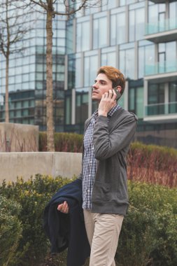 Genç adam telefonda konuşuyor.