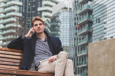Genç adam telefonda konuşuyor.