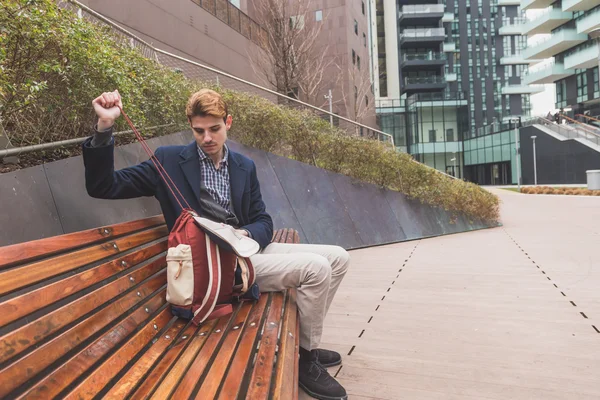 Young man sitting on a bench — Stock Photo, Image