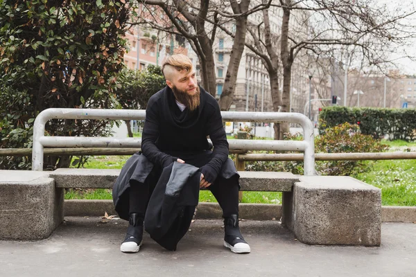 Stilvoller bärtiger Mann sitzt auf einer Bank — Stockfoto