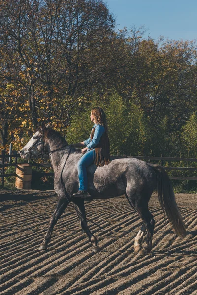 Красивая девушка верхом на серой лошади — стоковое фото