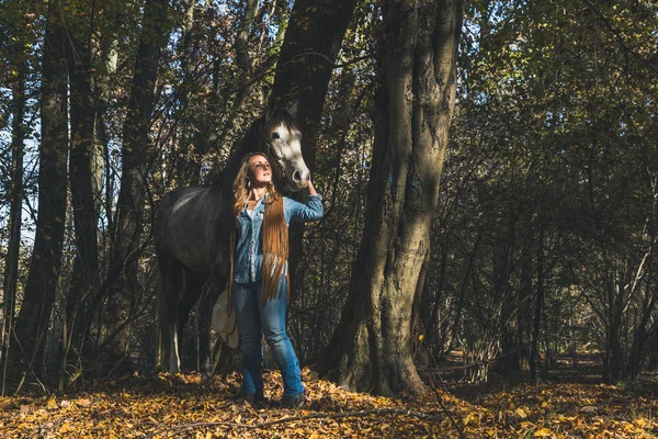 Menina bonita em pé por seu cavalo cinza — Fotografia de Stock