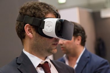 Milano'daki Technology Hub'da sanal gerçeklik kulaklığı deneyen adam, ben