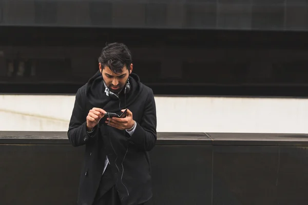 Bonito homem indiano mensagens de texto em um contexto urbano — Fotografia de Stock