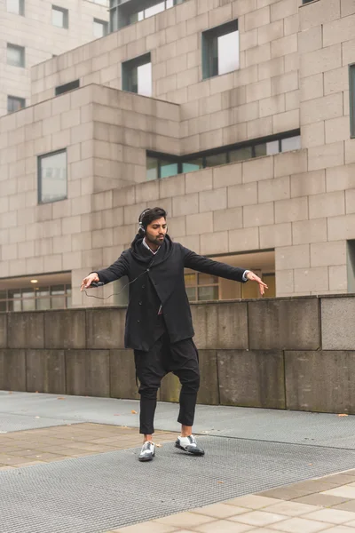 Schöner indischer Mann, der Musik im urbanen Kontext hört — Stockfoto