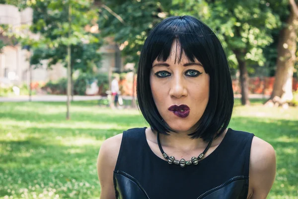 Pretty goth girl posing in a city park — Stock Photo, Image