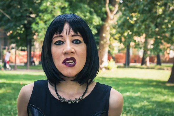 Pretty goth girl posing in a city park — Stock Photo, Image