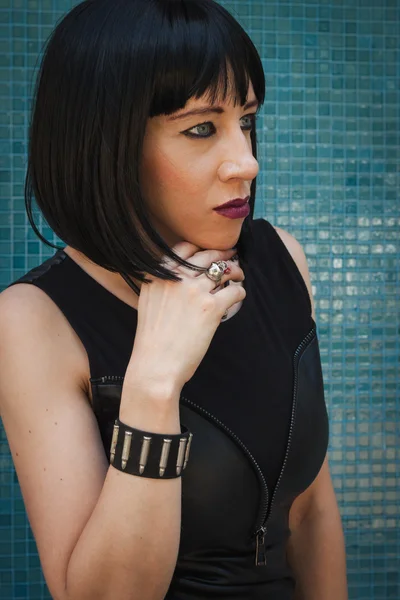 Pretty goth girl posing against a blue wall — Stock Photo, Image