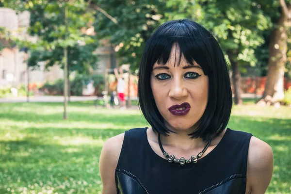 Pretty goth girl posing in a city park — Stock Photo, Image
