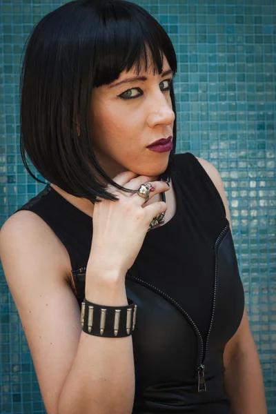 Pretty goth girl posing against a blue wall — Stock Photo, Image