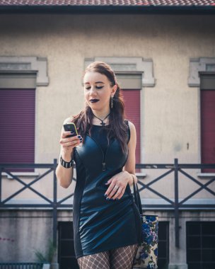 Telefonunuzun ve Şehir Parkı içinde güzel Gotik kız