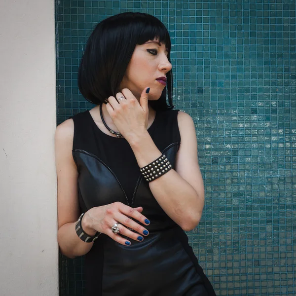 Pretty goth girl posing against a blue wall — Stock Photo, Image