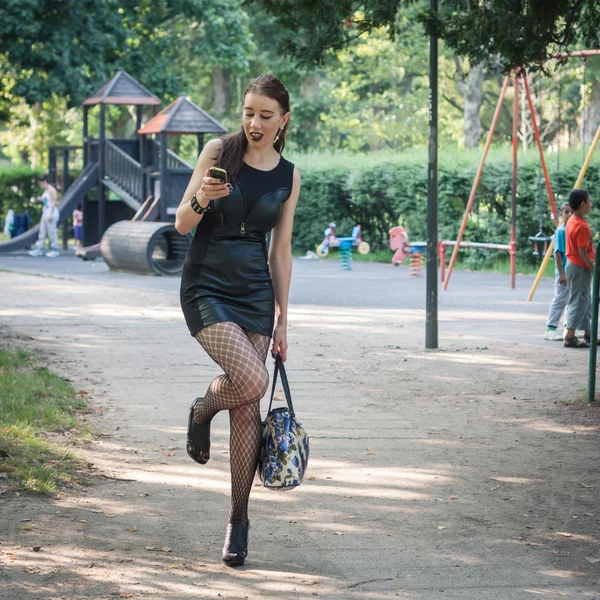 Hübsche goth Mädchen mit Handy in einem Stadtpark — Stockfoto