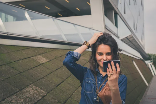 Hezká dívka pózuje v ulicích města — Stock fotografie